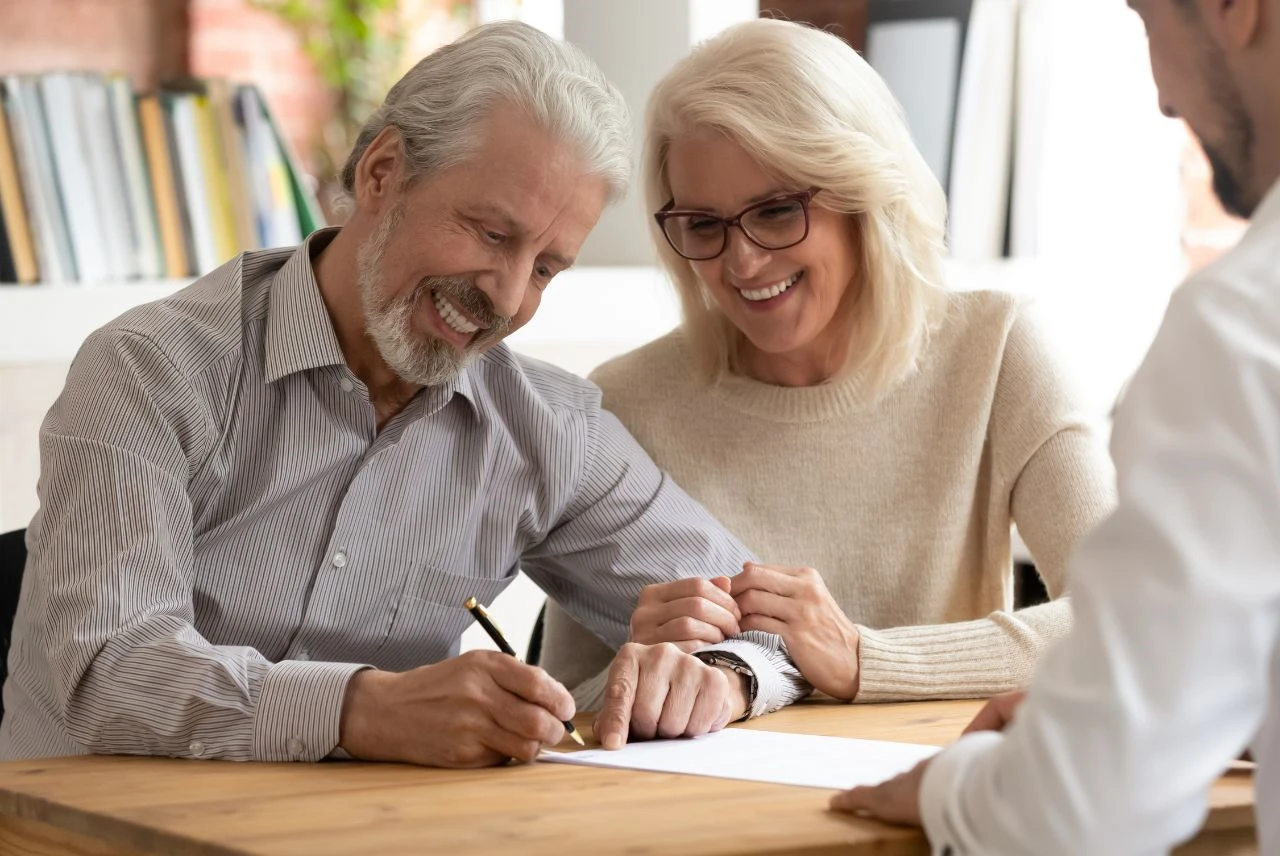 A couple signing documents with a tax advisor, representing hardship notices and Offer in Compromise relief