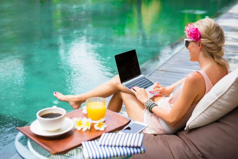 Digital nomad working on laptop by pool in Thailand enjoying remote work lifestyle